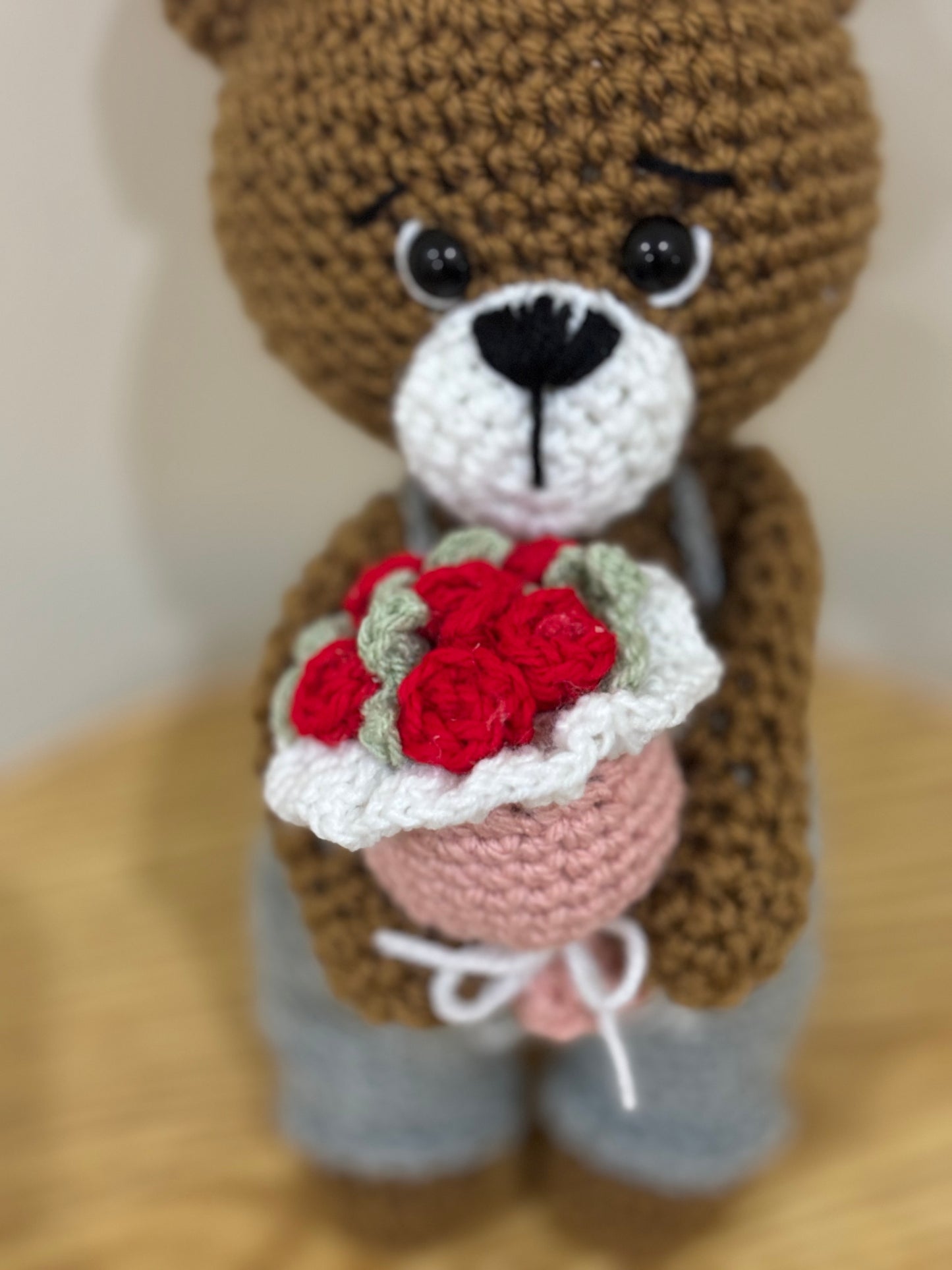 Crochet bear holding roses bouquet