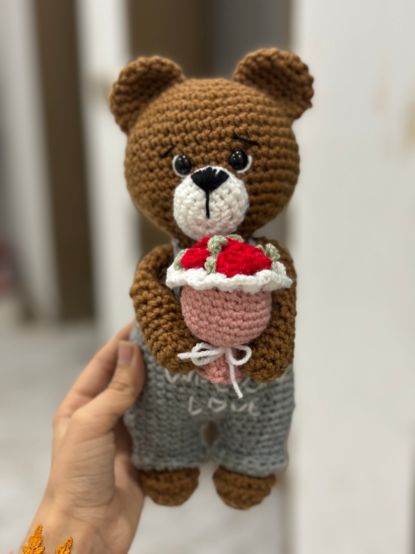 Crochet bear holding roses bouquet