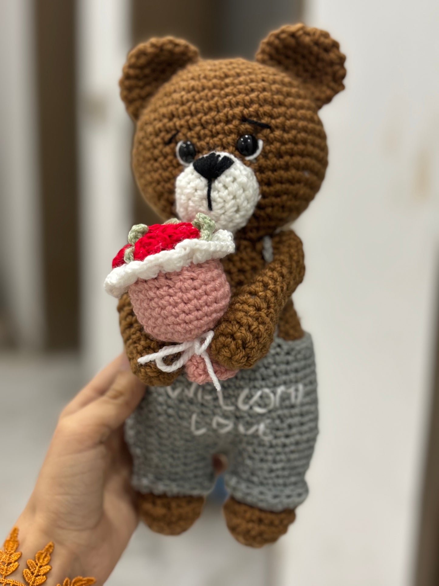 Crochet bear holding roses bouquet