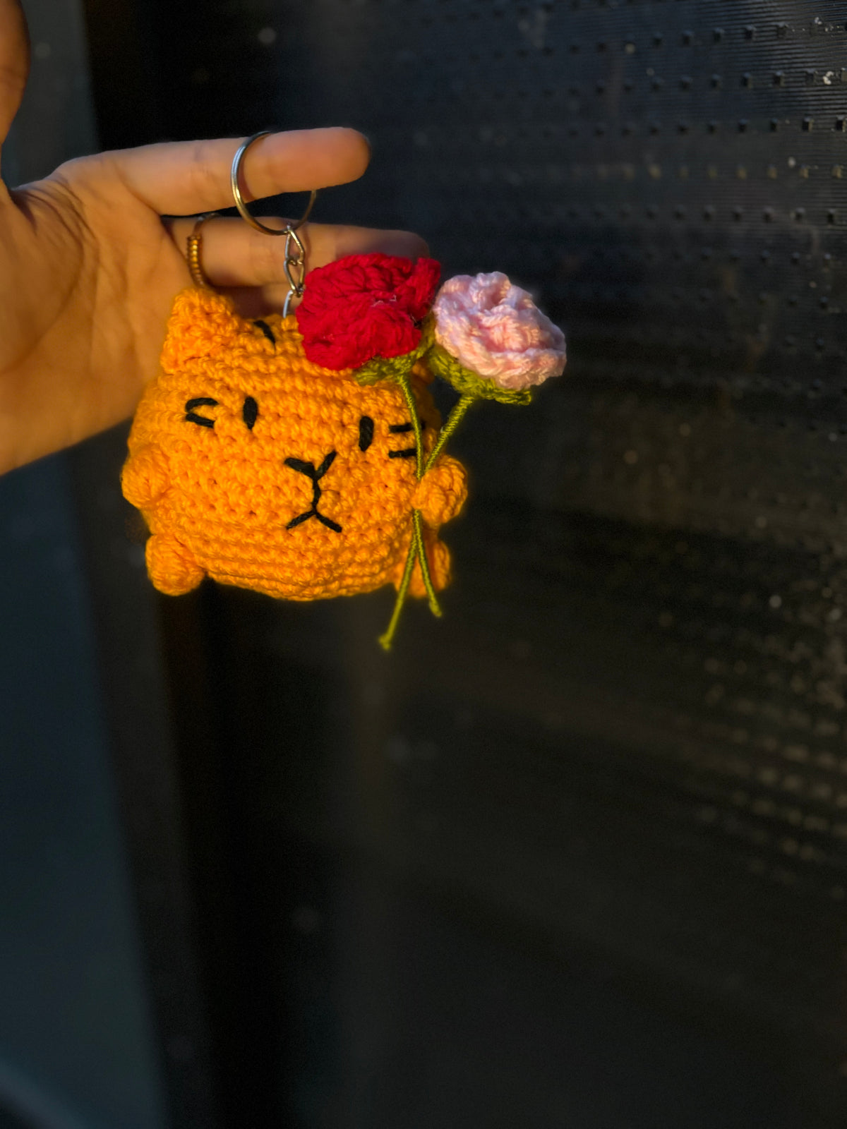 Crochet cat holding roses