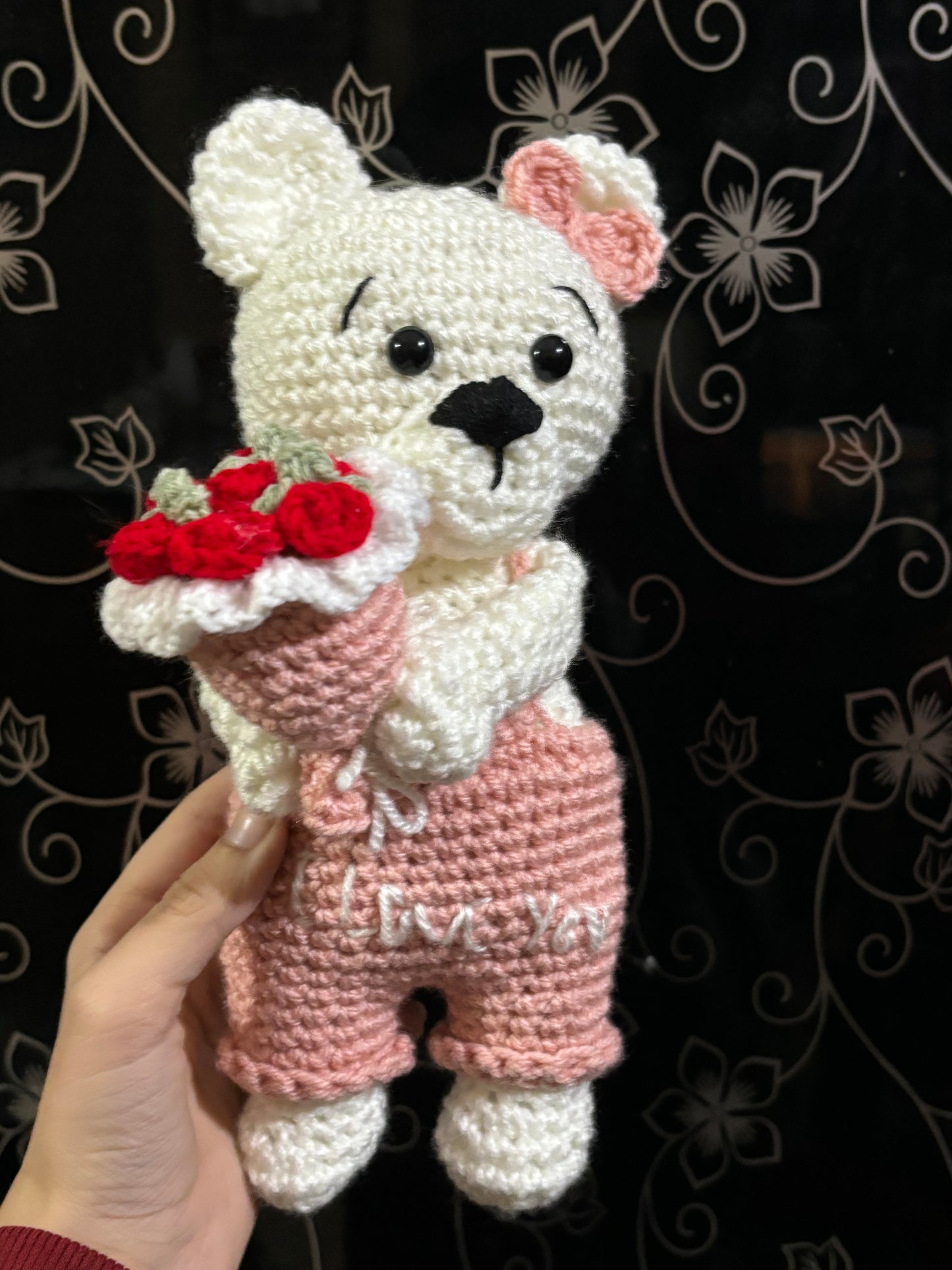 Crochet bear holding roses bouquet