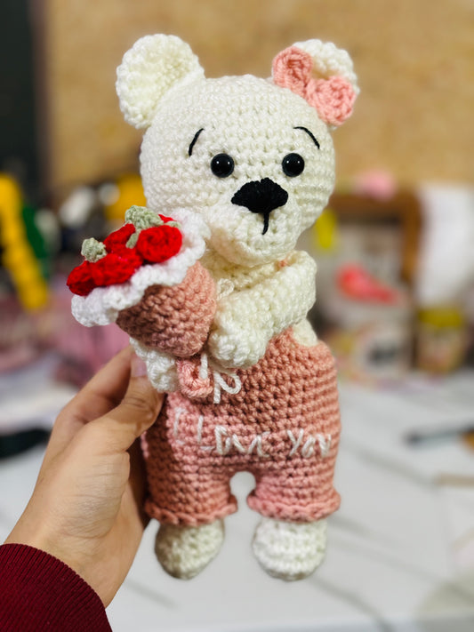 Crochet bear holding roses bouquet