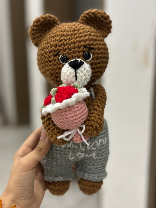 Crochet bear holding roses bouquet