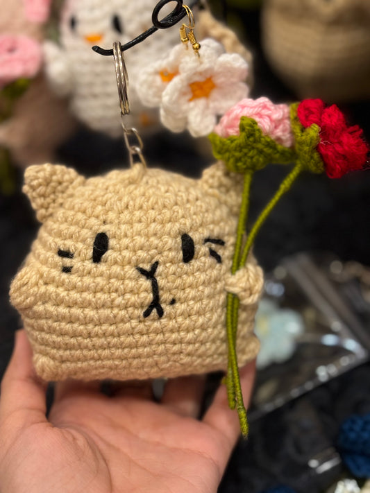 Crochet cat holding roses