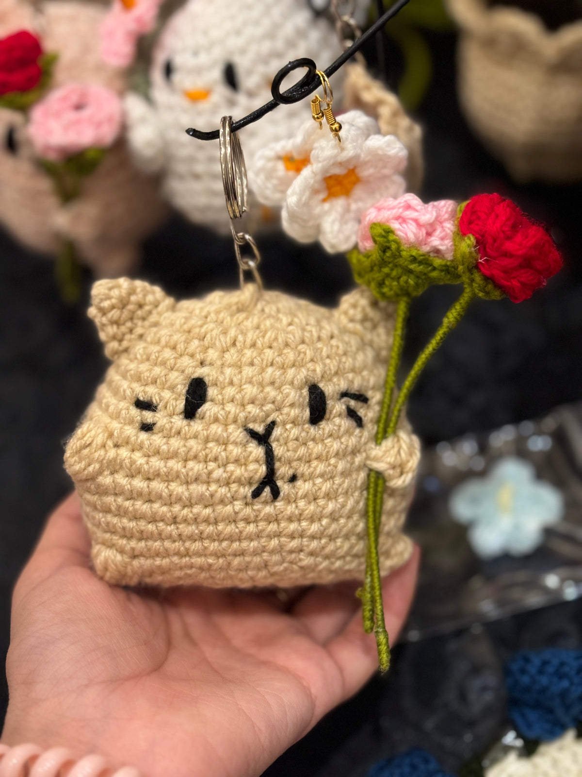Crochet cat holding roses