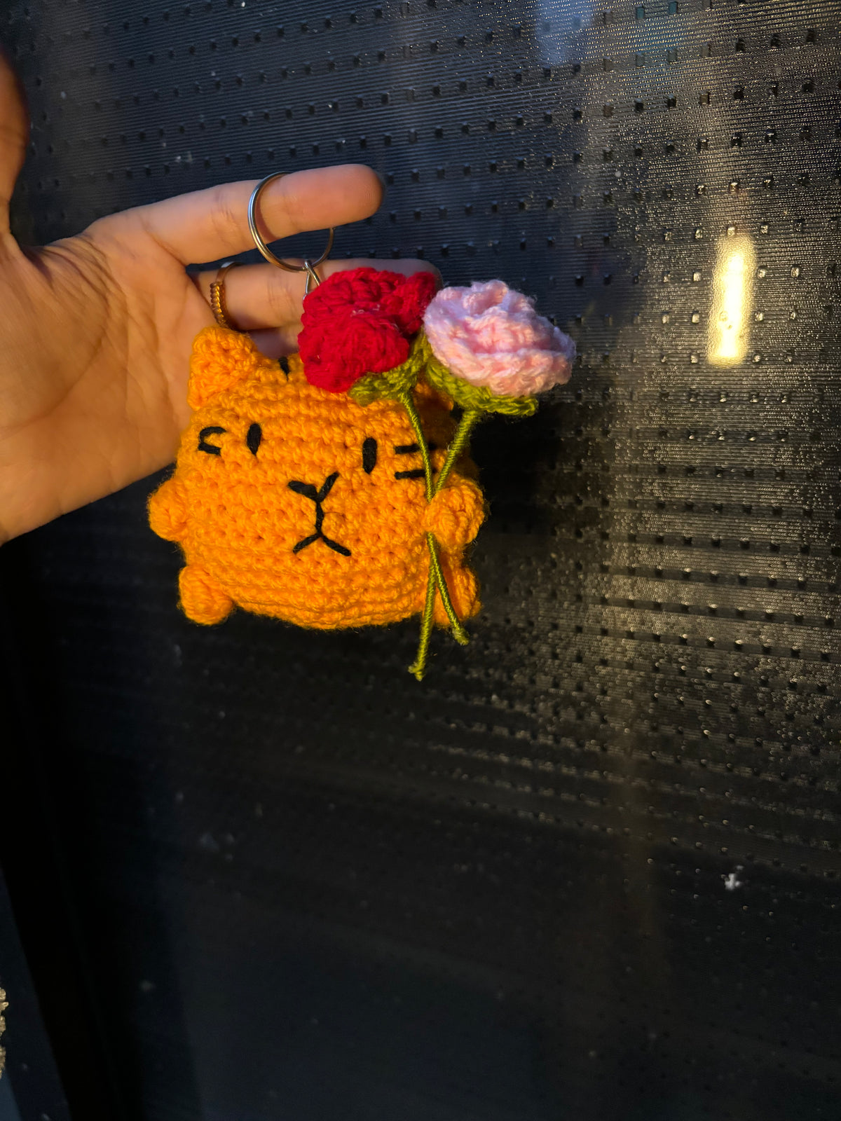 Crochet cat holding roses
