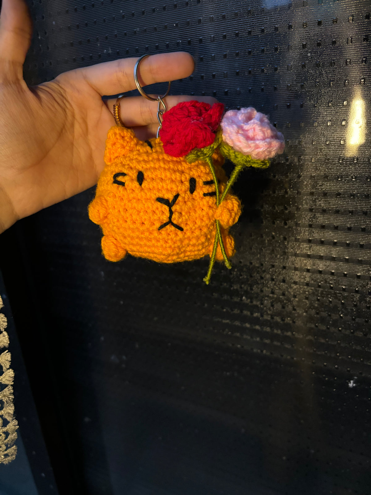 Crochet cat holding roses